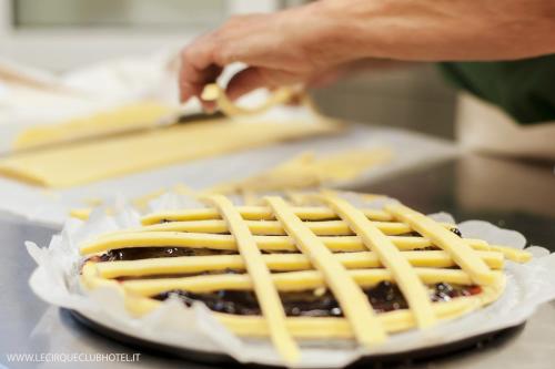 a person is making a waffle with cheese on it at Hotel Lido Inn in Lido di Camaiore