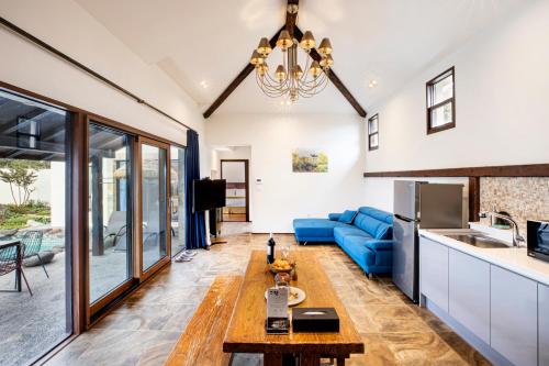 a living room with a blue couch and a table at Olle Resort in Jeju