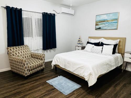 a bedroom with a bed and a chair at MenPour Apartments Complex in Koolbaai