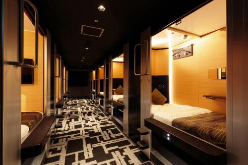uma fila de camas num quarto em MyCUBE by MYSTAYS Asakusa Kuramae em Tóquio