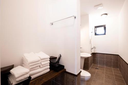 a white bathroom with a toilet and a sink at Olle Resort in Jeju