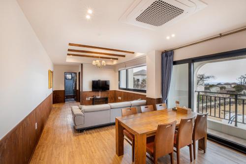a living room with a table and a couch at Olle Resort in Jeju