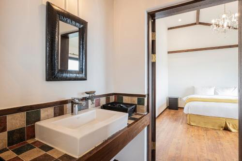a bathroom with a sink and a bed at Olle Resort in Jeju