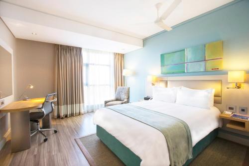 a hotel room with a bed and a desk at Holiday Inn Mauritius Mon Trésor by IHG in Blue Bay