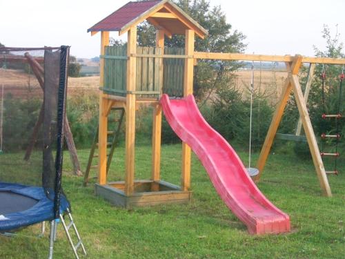 un parque infantil de madera con un tobogán y un columpio en Agroturystyka na Górce en Nowa Wies