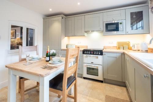 a kitchen with a table and chairs in a kitchen at 1 Chantry Cottage in Tunstall