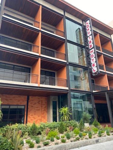 an apartment building with a sign in front of it at Loft122 Hotel in Ban Zong Katiam