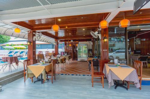a dining room with tables and chairs and tablesktop at Rabbit Mansion Patong - SHA Plus in Patong Beach