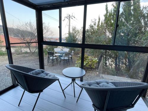 a room with two chairs and a table in front of a window at Tiz wan 洲本 in Sumoto