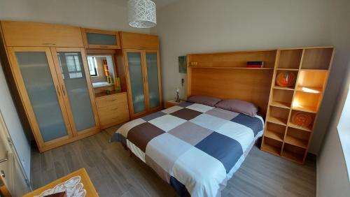 a bedroom with a large bed and wooden cabinets at Trilogy, Ample Penthouse, Gozo in Kerċem