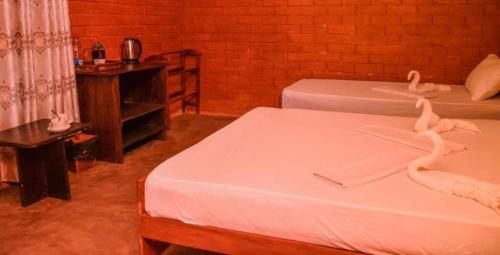 two beds in a room with swans on them at Sinharaja Forest Gate in Deniyaya