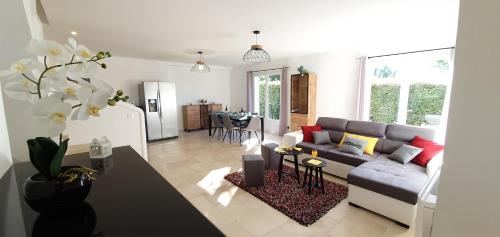 un salon avec un canapé et une table dans l'établissement Maison calme et rénovée 