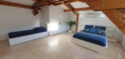 een slaapkamer met 2 bedden in een kamer met houten plafonds bij Maison calme et rénovée "Oléa Provence" à 20mn d'Aix-en-Provence et Gare TGV in Saint-Cannat