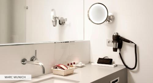 a bathroom with a mirror and a sink at Marc München in Munich