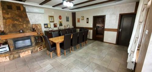 Pensiunea Raiul Munților في Sebiş: غرفة طعام مع طاولة وكراسي ومدفأة