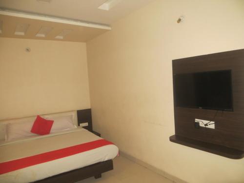Habitación de hotel con cama y TV de pantalla plana. en Hotel Aaradhy, en Ujjain