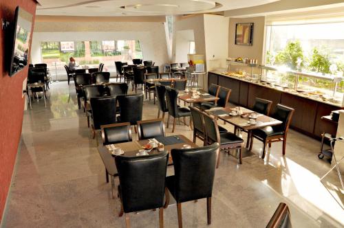 a restaurant with tables and chairs and a bar at Hotel Real Alameda de Queretaro in Querétaro