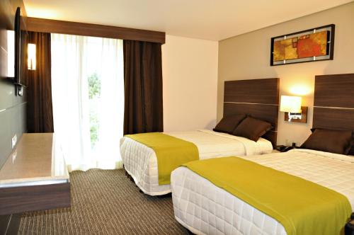 מיטה או מיטות בחדר ב-Hotel Real Alameda de Queretaro
