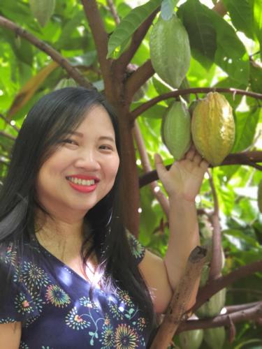 a woman is standing next to a lime tree at Saengcha Farm Resort in Prachin Buri