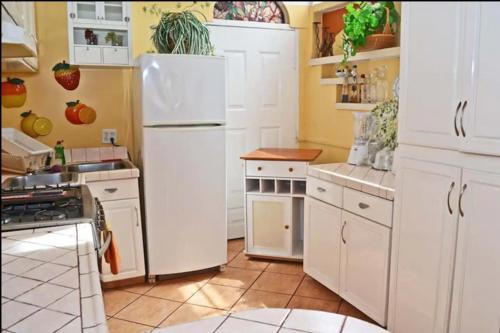 a kitchen with white cabinets and a white refrigerator at Welcome to Casa Viva Mexico 3-bedrooms 2-bathroms 6-Guests close to Shoping Center & Beach in Tijuana