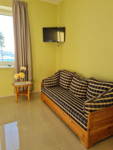 a living room with a couch and a tv on the wall at Grundenberga hotel with self check-in in Baldone