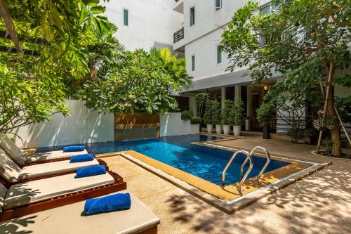 a swimming pool with lounge chairs next to a building at Sovanna Hotel in Phnom Penh