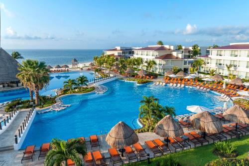 an aerial view of a resort pool with chairs and the ocean at Moon Palace Nizuc - All Inclusive in Cancún