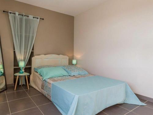 Schlafzimmer mit einem Bett mit blauer Bettwäsche und einem Fenster in der Unterkunft Gîte Pornic-Le Clion sur Mer, 2 pièces, 2 personnes - FR-1-306-1037 in Pornic