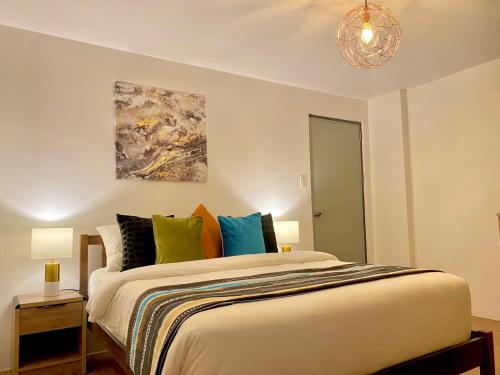 um quarto com uma cama grande e almofadas coloridas em UNWND Residences Dumaguete em Dumaguete
