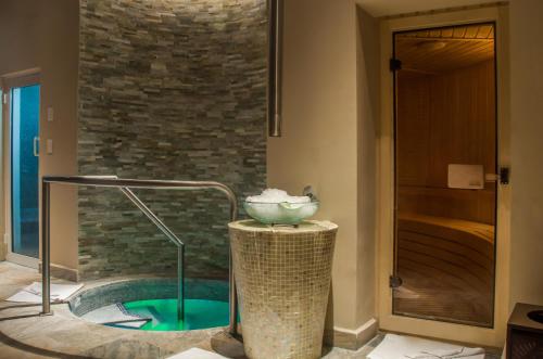 a bathroom with a tub with a bowl in it at Playacar Palace - All Inclusive in Playa del Carmen