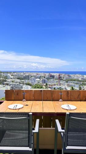 a table with chairs and a view of a city at Sea View & More… in Saint-Denis