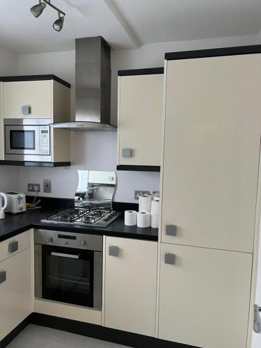 a kitchen with white cabinets and a stove top oven at one bedroom in Mill Hill