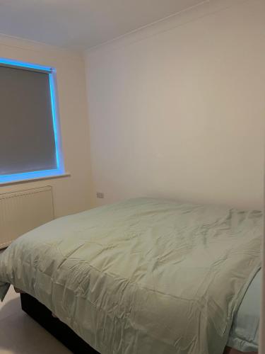 een bed in een witte kamer met een raam bij one bedroom in Mill Hill