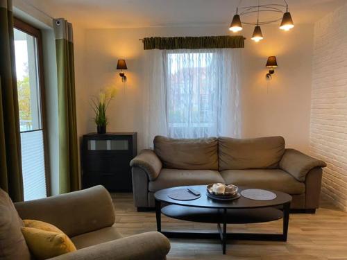 a living room with a couch and a table at Inalda in Ełk