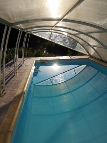 - une piscine dans une maison avec un toit dans l'établissement Eco-Gîte de L'Etang Présent, à Hornaing