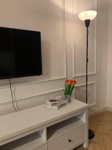 a living room with a tv and a table with flowers at Hidden Gem @ Marina View Villas PD in Port Dickson