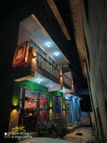 a building with a balcony on top of it at night at SUMAN GUEST HOUSE in Katra