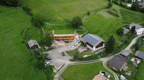 eine Luftansicht eines großen Hauses auf einem Feld in der Unterkunft Obergereuth Hof in Sankt Martin in Passeier