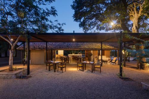 a pavilion with tables and chairs at night at Koragaha Lodge - Yala in Tissamaharama