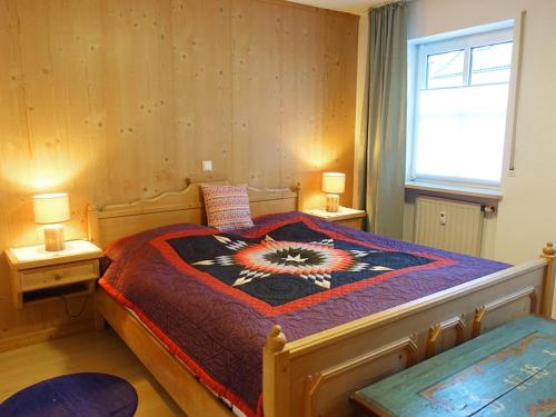 a bedroom with a large bed with a colorful blanket at Ferienwohnung Liparis in Bad Birnbach