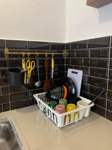 a dish rack with utensils on a kitchen counter at Hidden Gem @ Marina View Villas PD in Port Dickson