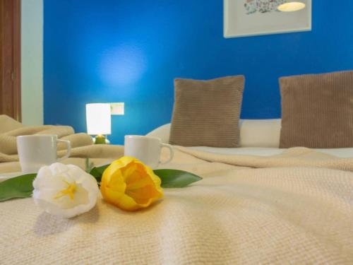 Una cama con dos flores encima. en Holidays2Malaga Plaza de Toros Vieja & terrace & optional parking, en Málaga