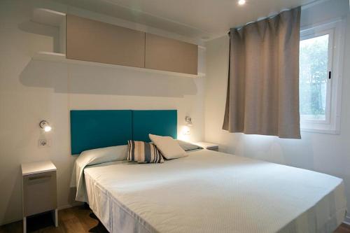 a bedroom with a large white bed and a window at Camping Europa in Capoliveri