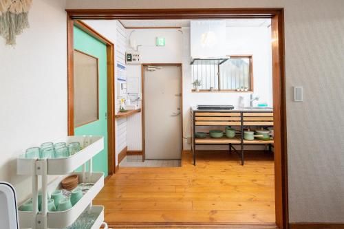 a room with a kitchen with a sink and a door at Leaf in Kamakura