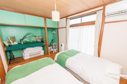 - une chambre avec 2 lits et une fenêtre dans l'établissement Leaf, à Kamakura