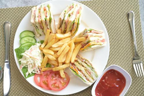 a plate with a sandwich and french fries and ketchup at Garden City Hotel Dubai in Dubai