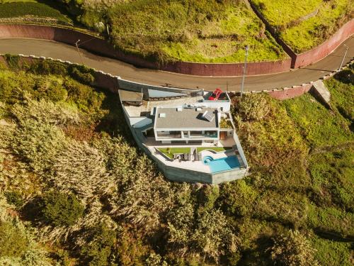an overhead view of a house on a hill with a road at The Cliffhouse by LovelyStay in Fajã da Ovelha
