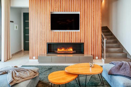 a living room with a fireplace and a table at The Cliffhouse by LovelyStay in Fajã da Ovelha