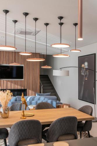 a dining room with a table and chairs and pendant lights at The Cliffhouse by LovelyStay in Fajã da Ovelha
