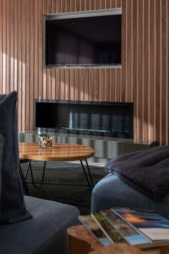 a living room with a coffee table and a television at The Cliffhouse by LovelyStay in Fajã da Ovelha